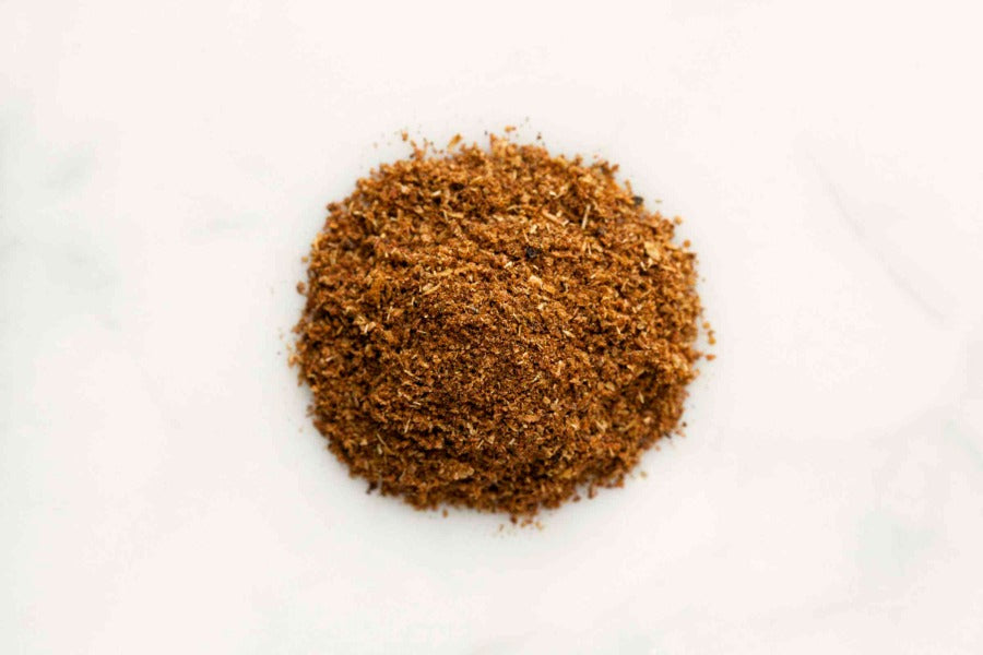 Chinese five-spice ground seasoning powder mound on white surface