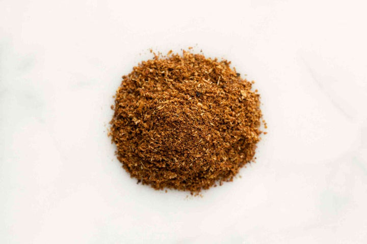 Chinese five-spice ground seasoning powder mound on white surface
