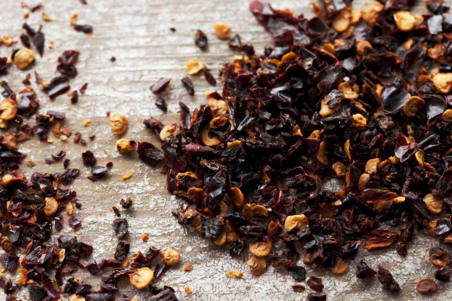 Chipotle chile flake seasoning, dark red-brown chile flakes in a pile