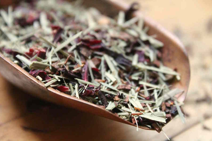 Loose tea leaves in a wooden scoop