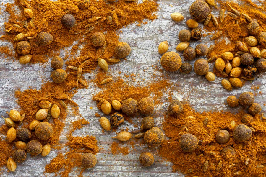 Curry spice blend with orange-yellow powder and whole spices