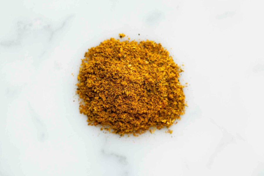 Single mound of finely ground yellow-orange curry spice powder