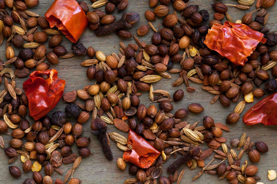Spice blend ingredients with seeds, husks, and dried red chili pieces