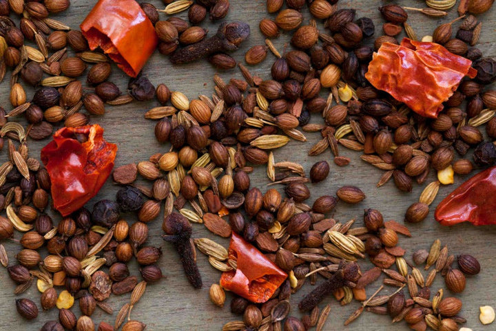 Spice blend ingredients with seeds, husks, and dried red chili pieces