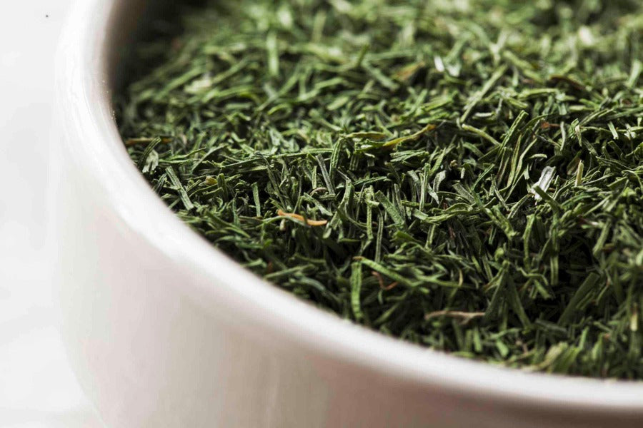 Dill weed cut and sifted, loose green herb in a white bowl