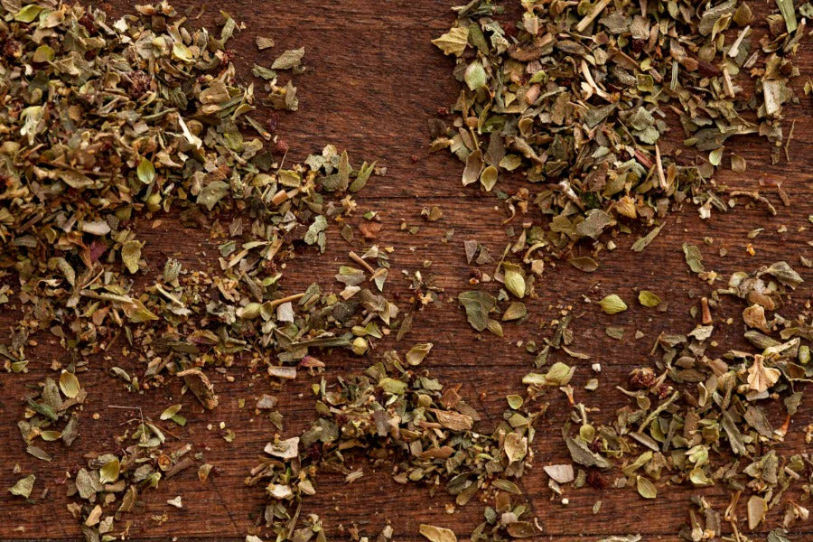 Dried herb and spice blend on wooden board, loose flakes