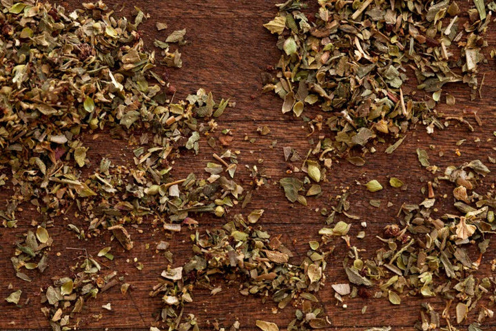 Dried herb and spice blend on wooden board, loose flakes