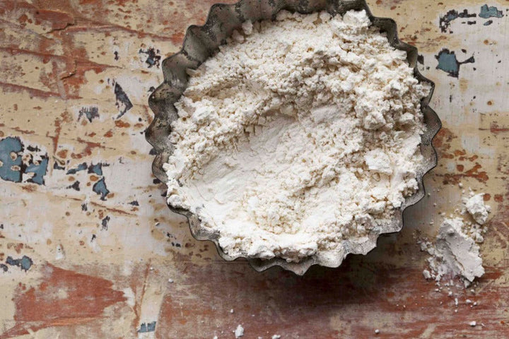 Garlic powder in a metal bowl, fine white seasoning