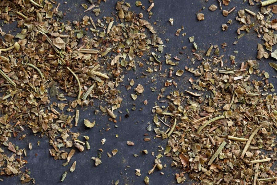 Loose Italian herb blend seasoning, dried green and brown leaf pieces