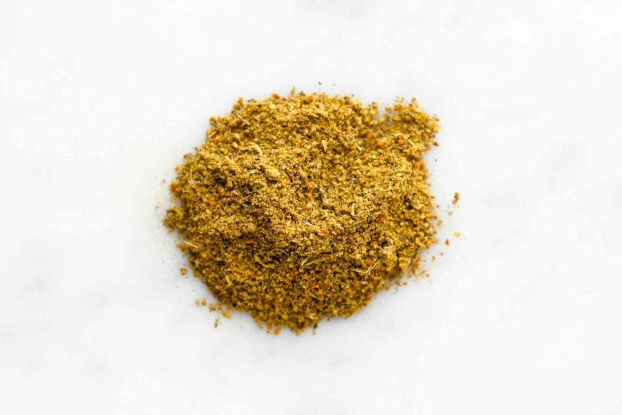 Ground jerk seasoning powder mound in yellow-gold spice texture