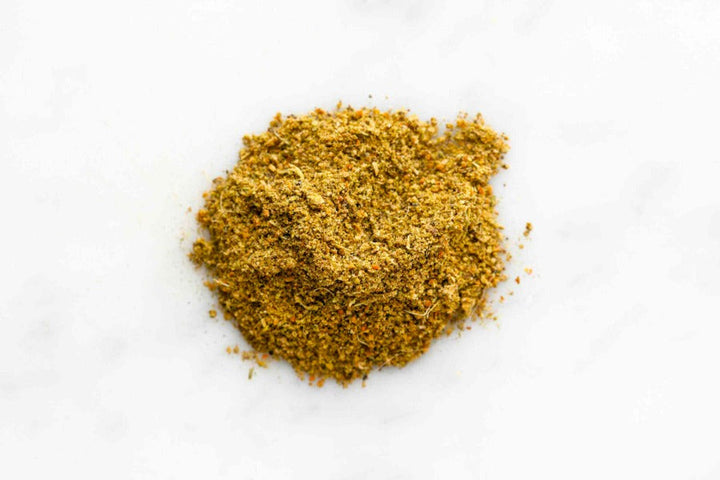 Ground jerk seasoning powder mound in yellow-gold spice texture
