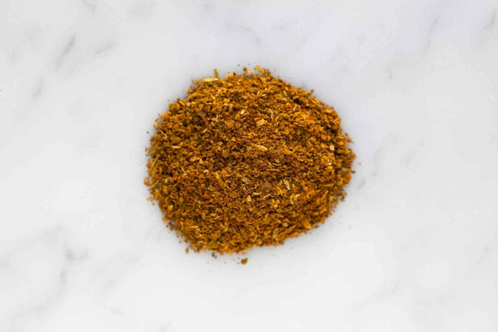 Khmeli Suneli ground spice blend mound, finely ground yellow-orange powder