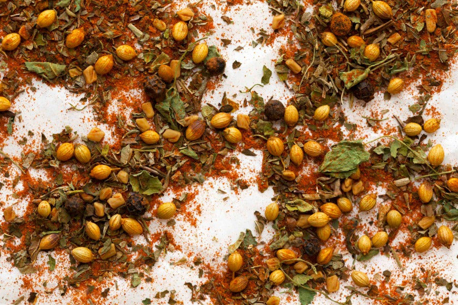 Khmeli Suneli spice blend scattered with dried herbs, seeds, and flakes