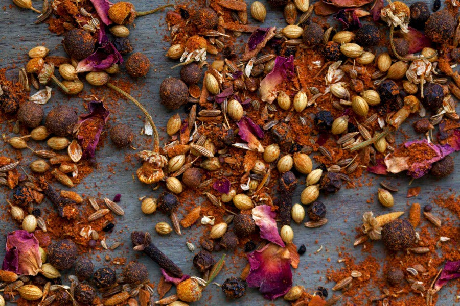 Ground spice blend with dried herbs and seeds, dark reddish-brown