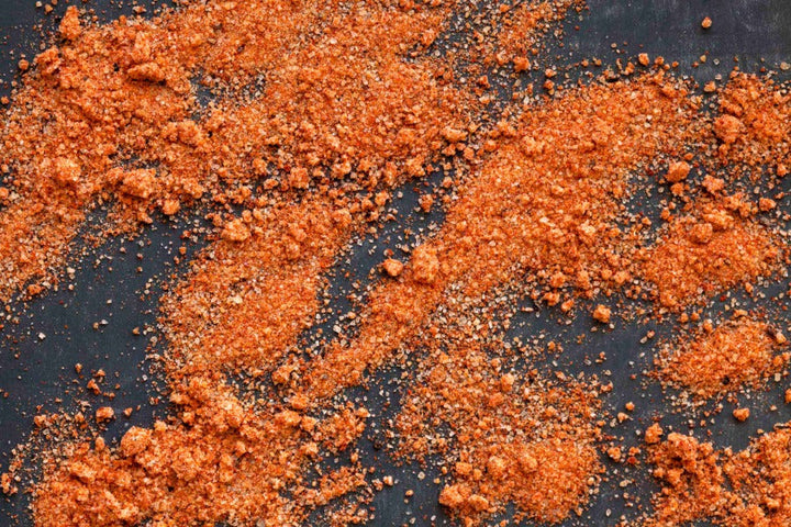 Coarse orange-red seasoned salt blend with speckled spices