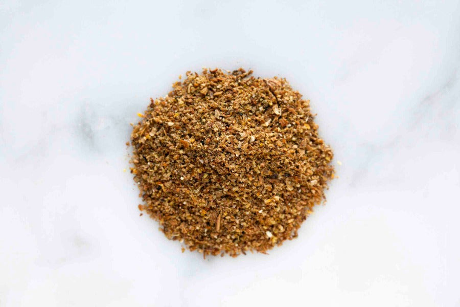 Ground salmon rub seasoning blend pile on a white background
