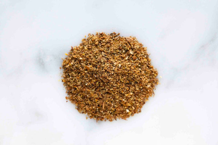 Ground salmon rub seasoning blend pile on a white background