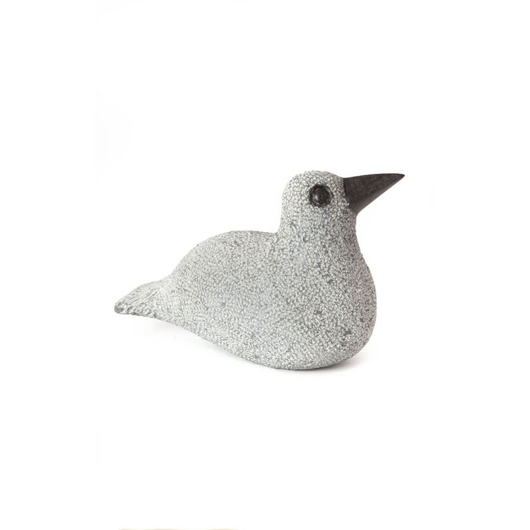 Stone duck sculpture lying down, speckled light gray body with dark beak and eye
