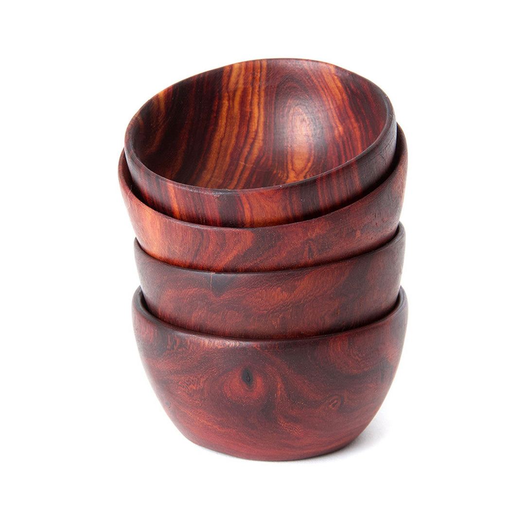 Stacked small teak bowls in reddish-brown with bold swirling wood grain