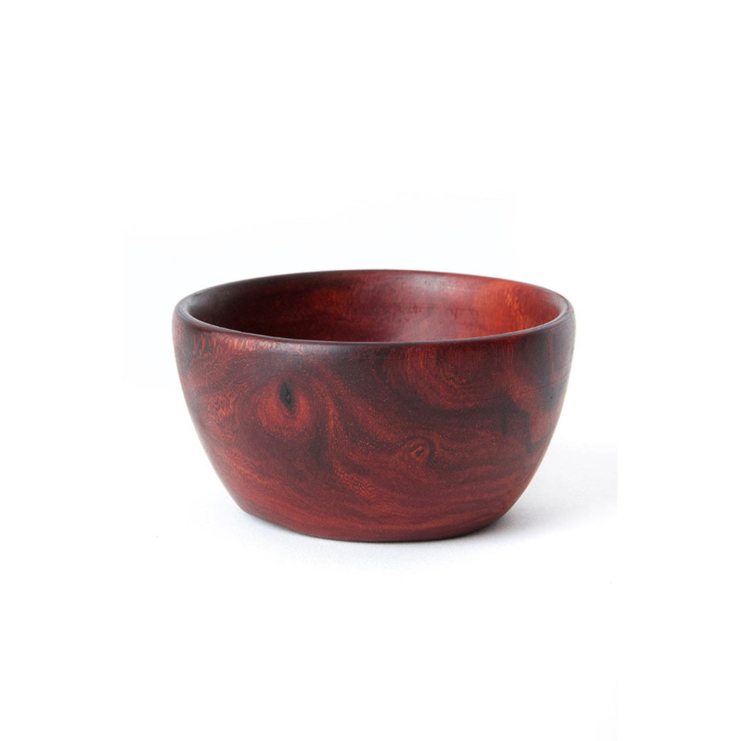Hand-carved small teak bowl in reddish-brown with visible swirling wood grain