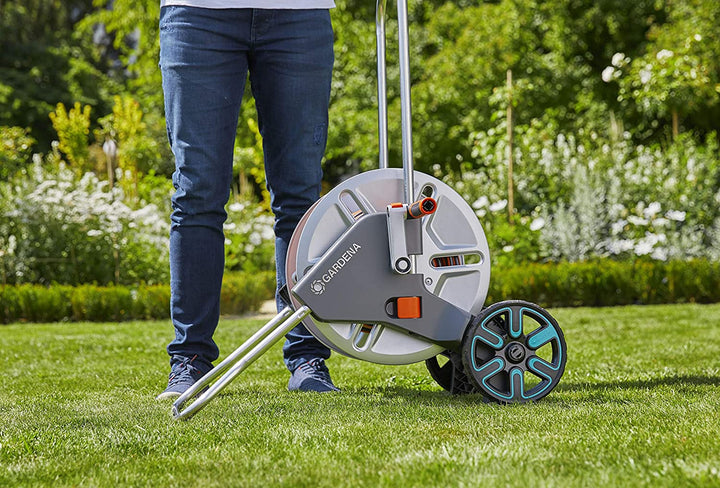 Metal hose reel cart with gray hose drum, orange hose, and four-wheel base