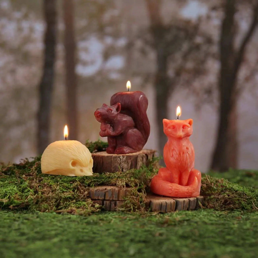 Hedgehog beeswax candle with lit wick on moss-covered wood disc