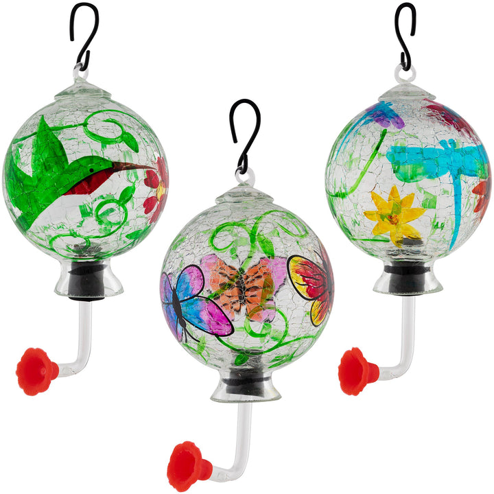 Set of three hanging hand-painted glass hummingbird feeders with colorful floral and bug designs