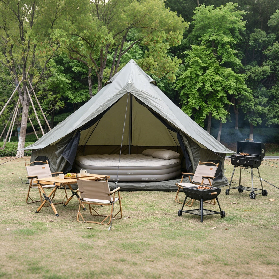 Bell tent with stove and seating outside, open doorway and overhead canopy peak