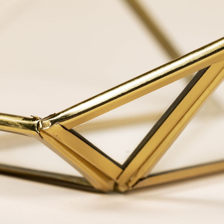 Close-up of gold metal frame joint on a hanging glass bird feeder