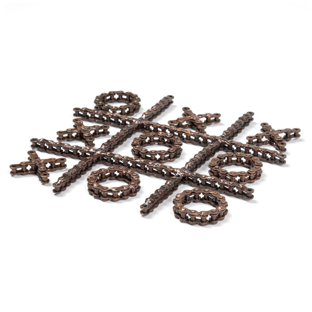 Recycled chain-link tic-tac-toe pieces scattered, with O rings, X crosses, and bars.