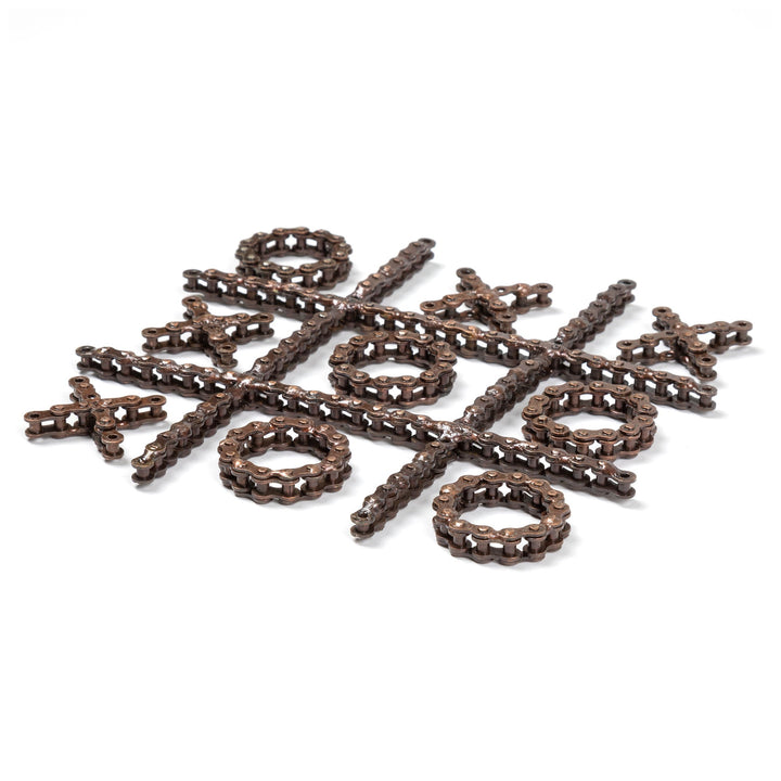 Recycled chain-link tic-tac-toe pieces scattered, with O rings, X crosses, and bars.