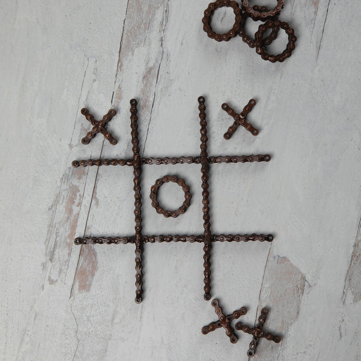 Recycled chain-link tic-tac-toe board layout with X crosses and O rings in a grid.