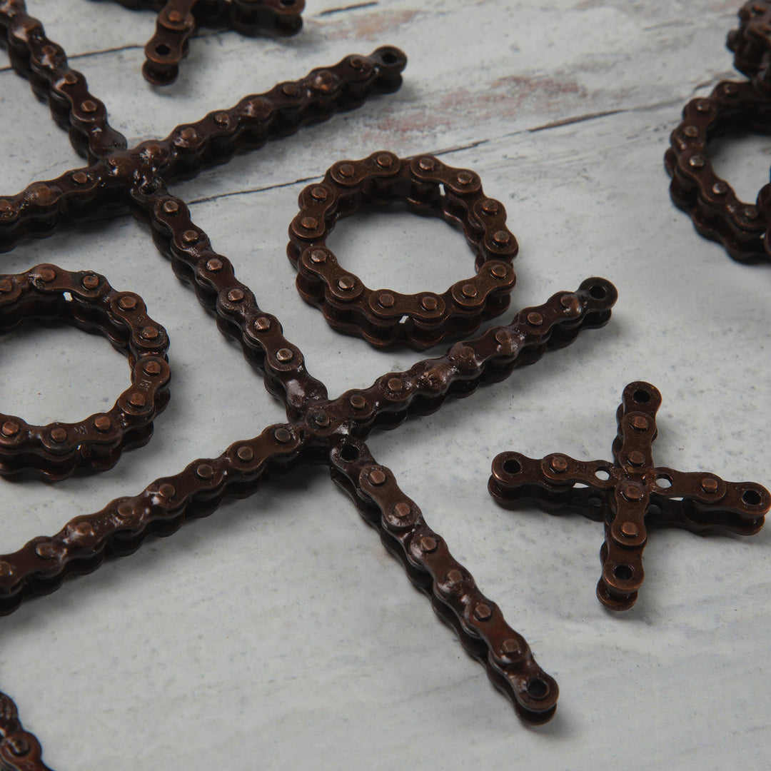 Recycled chain-link tic-tac-toe close-up showing O rings and X cross pieces.