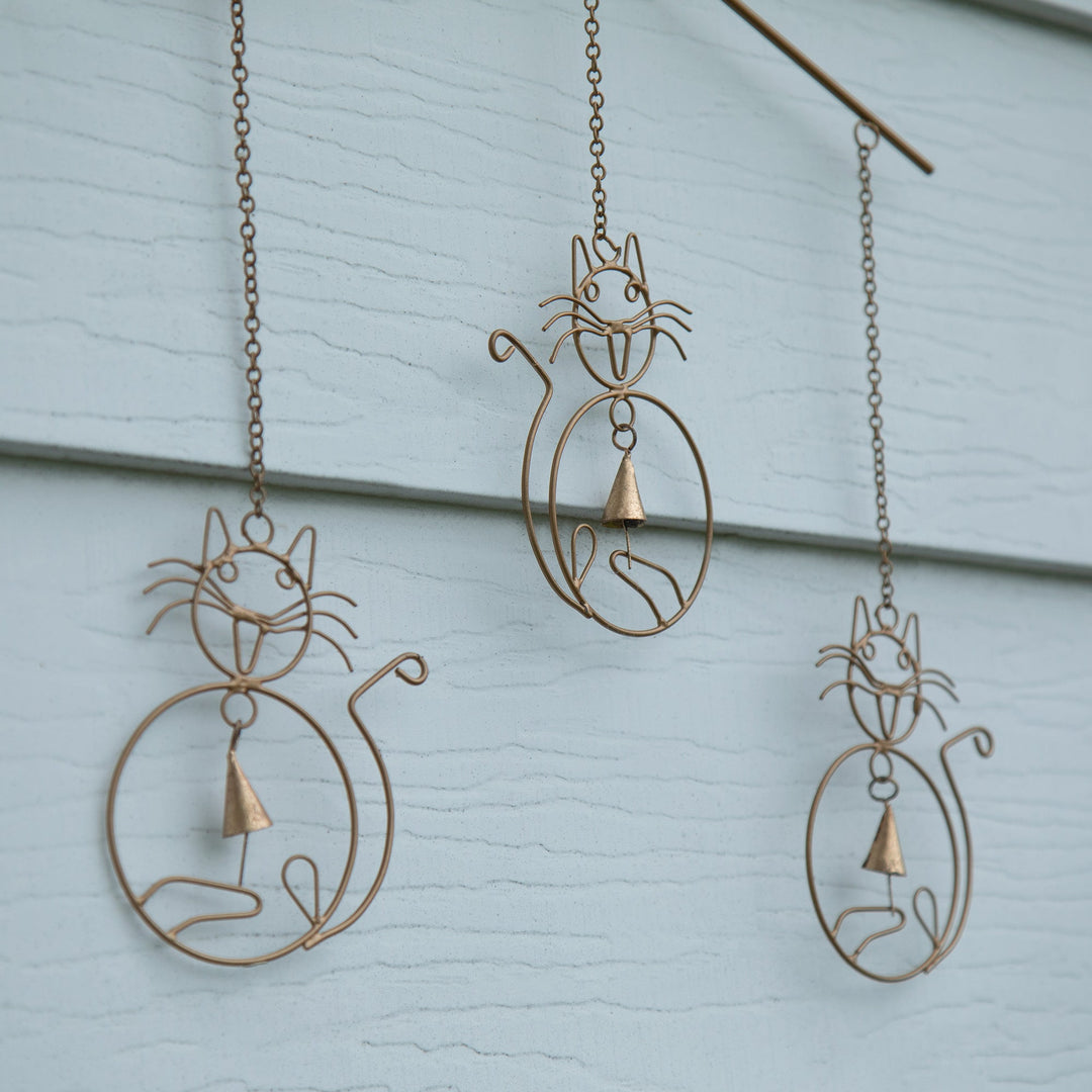 Iron wind chime close-up: metal cat silhouettes with small bell accents
