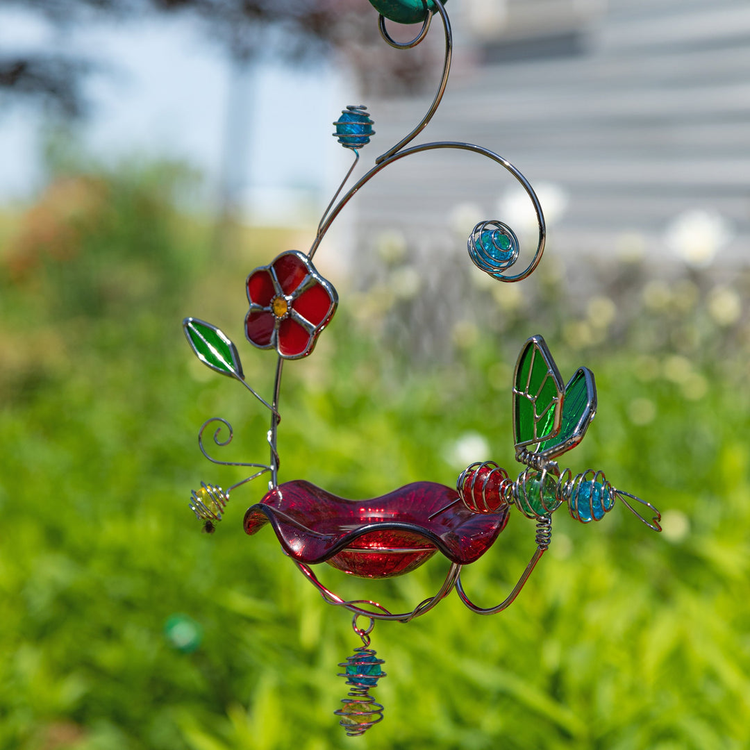 Stained glass hummingbird feeder with red bird, blue swirls, and green leaf accents, hanging hook.