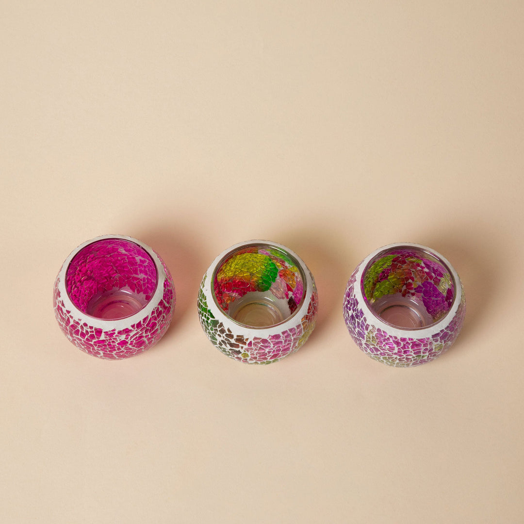 Three mosaic votive holders viewed from above, open metal-rimmed tops