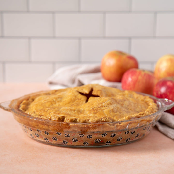 Amber-tinted glass pie plate with paw-print decoration and scalloped edge