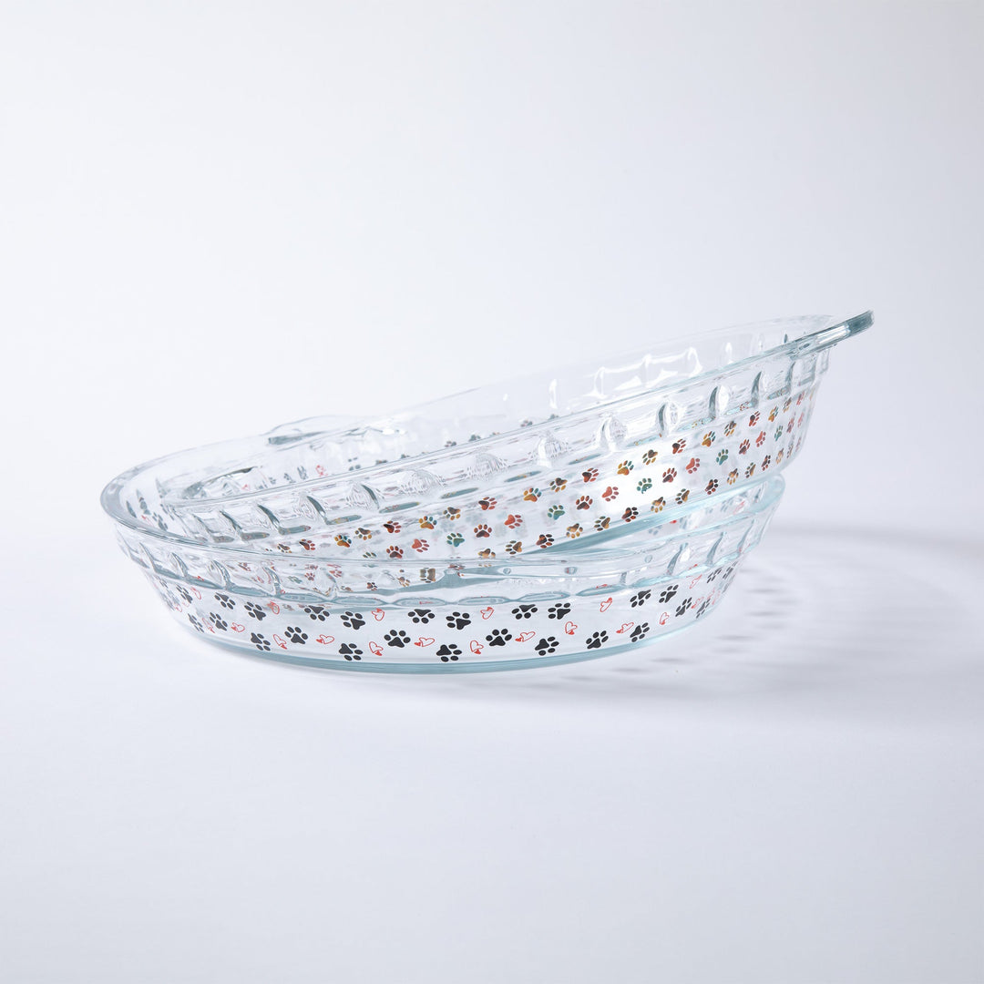 Clear glass pie plate with colorful paw-print pattern and oval shape