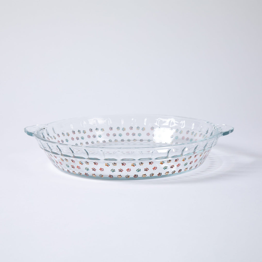 Clear glass pie plate with colorful paw-print pattern and short side rim