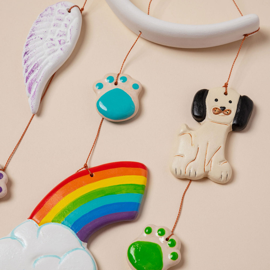 Ceramic pet memorial wind chime close-up of rainbow, paw ornaments, and dog charm