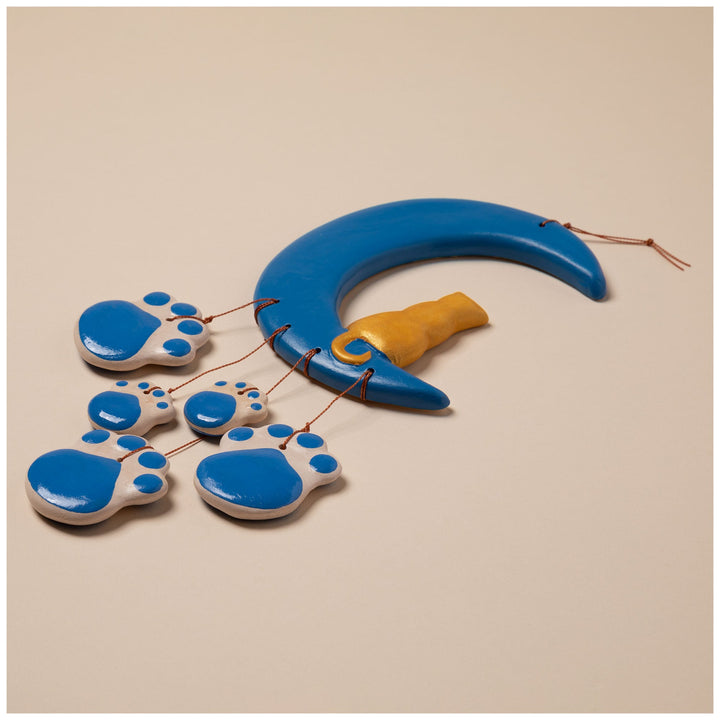 Ceramic moon wind chime with blue curved moon, gold cat charm, and blue paw discs