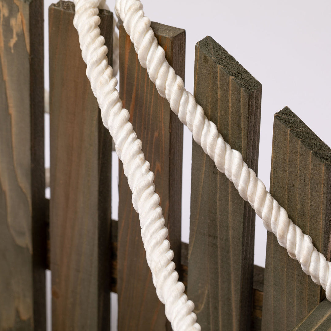 Close-up of hanging feeder slatted wood panels with braided white rope