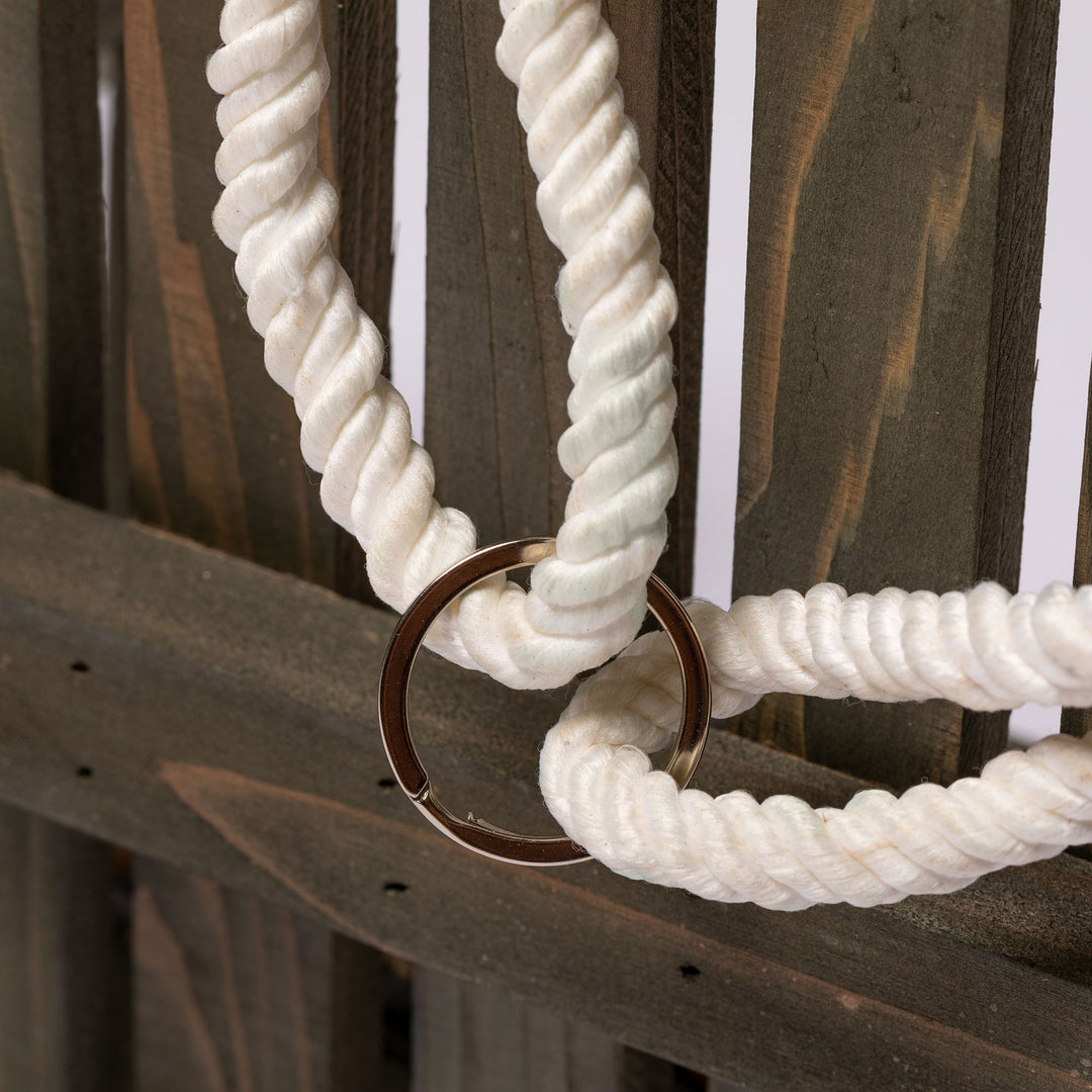 Close-up of feeder braided rope with metal ring attachment and slatted wood