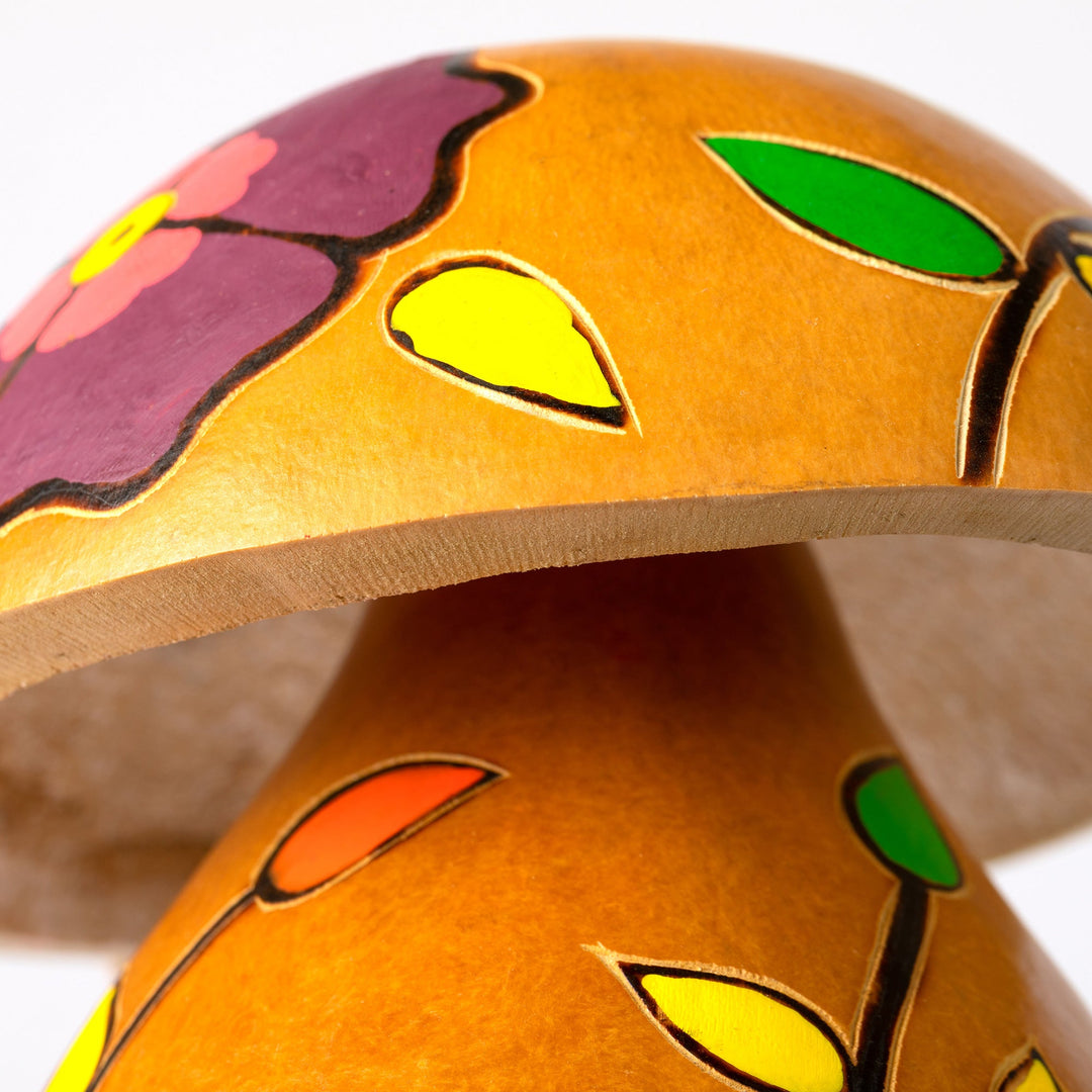 Hand-painted gourd birdhouse top close-up with painted leaves and open cap