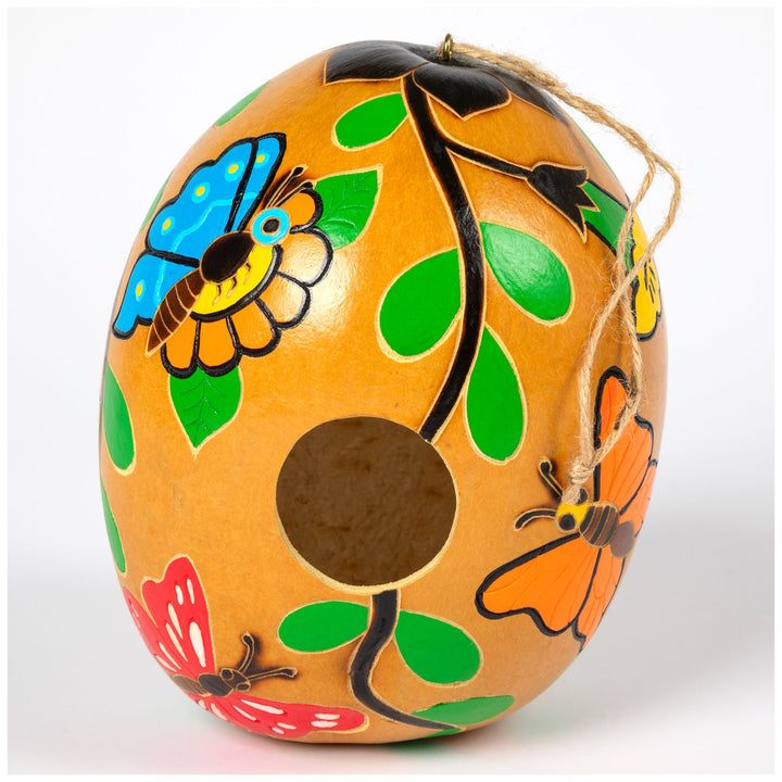 Hand-painted gourd birdhouse close-up with painted bee and green leaf accents