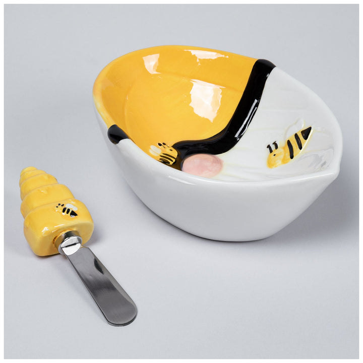 Bee ceramic serving bowl with yellow top and black trim, with matching spreader