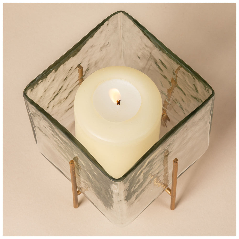 Diamond-top square glass tea light holder with burning candle and brass support legs