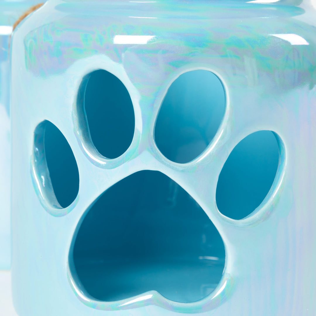Close-up of blue glass paw-print candle holder with cutout design