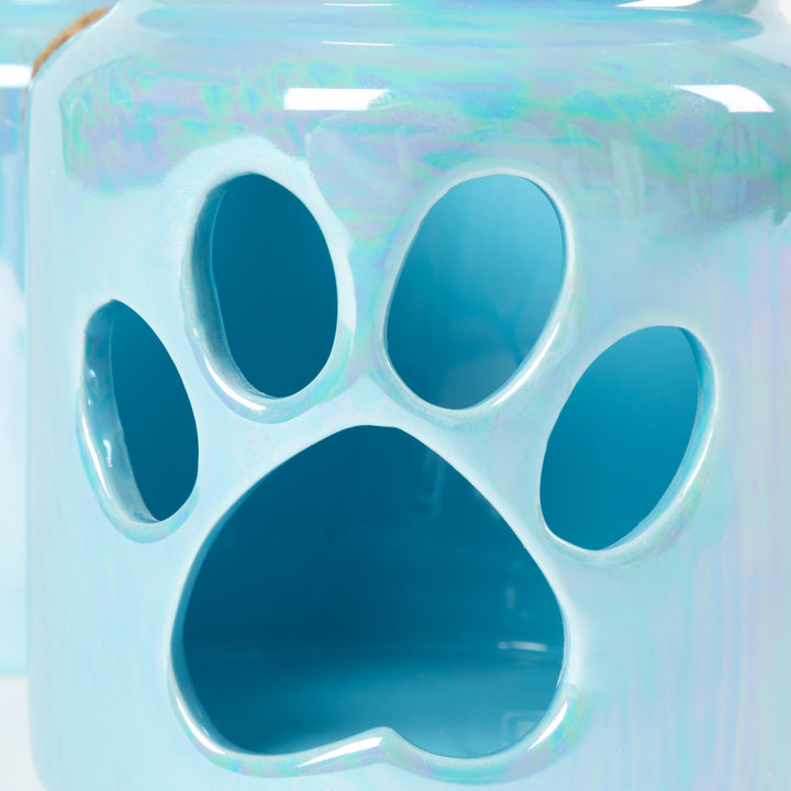 Close-up of blue glass paw-print candle holder with cutout design