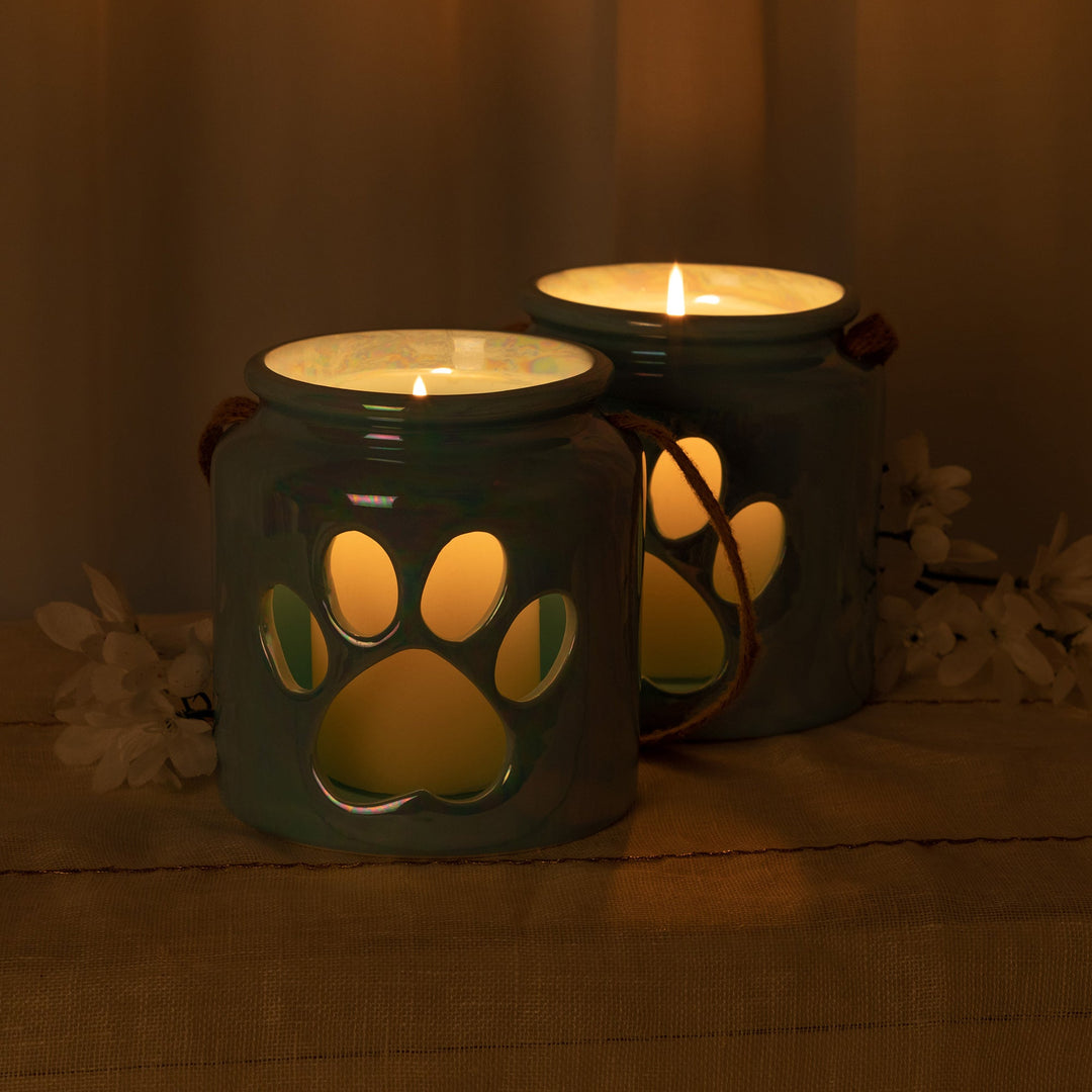 Blue paw-print glass candle holders with lit candles and rope handles